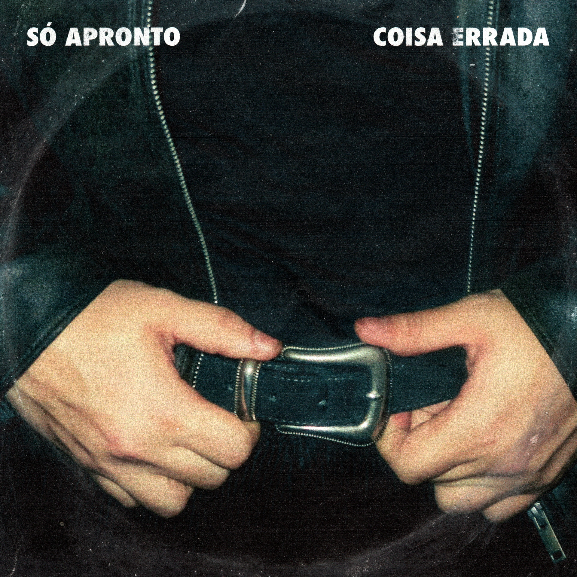 Photographic cover for Só Apronto Coisa Errada, showing hands at a belt buckle beneath a dark denim jacket.