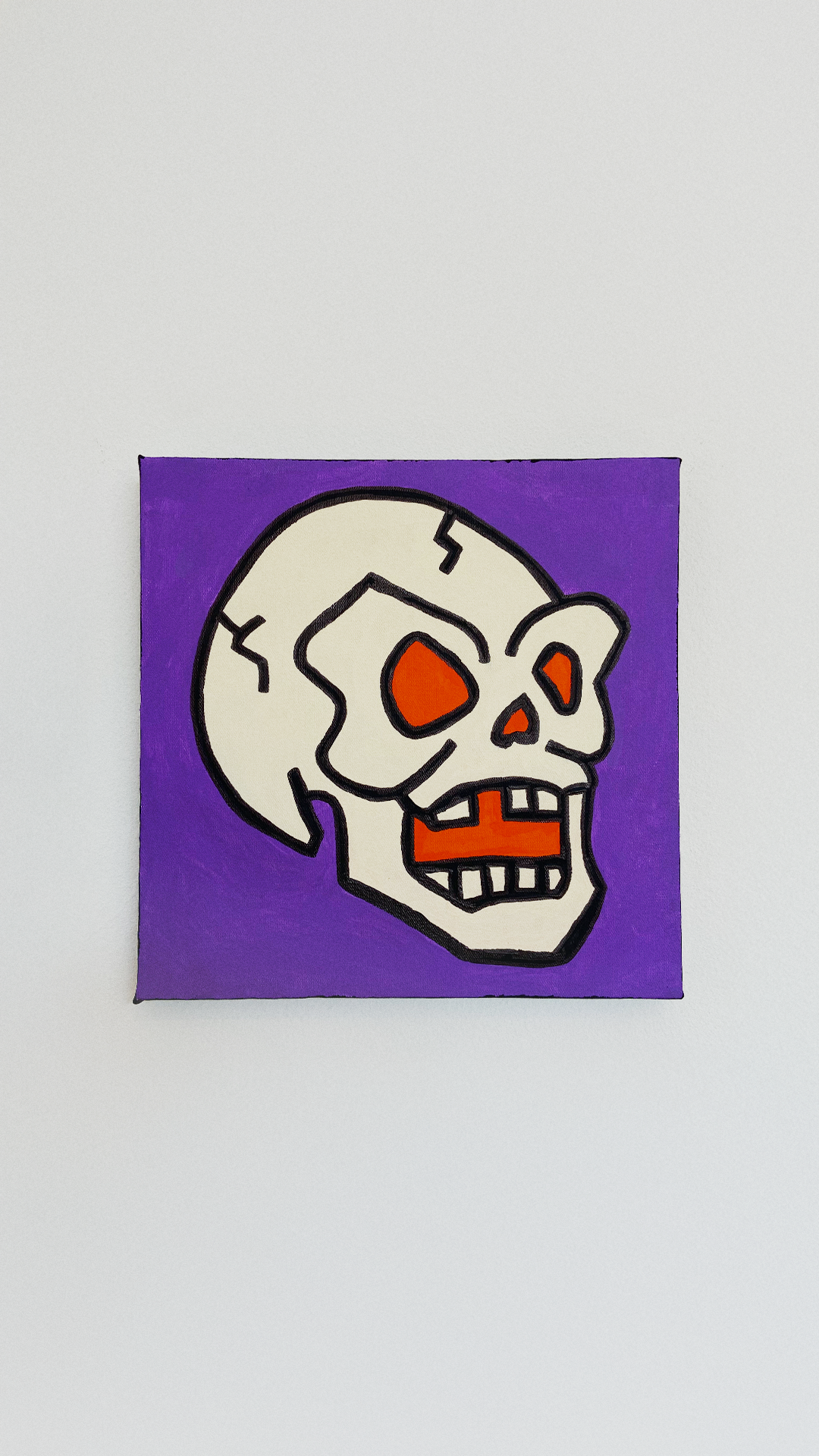A cream-colored skull with orange eyes and mouth, outlined in black against a purple background.