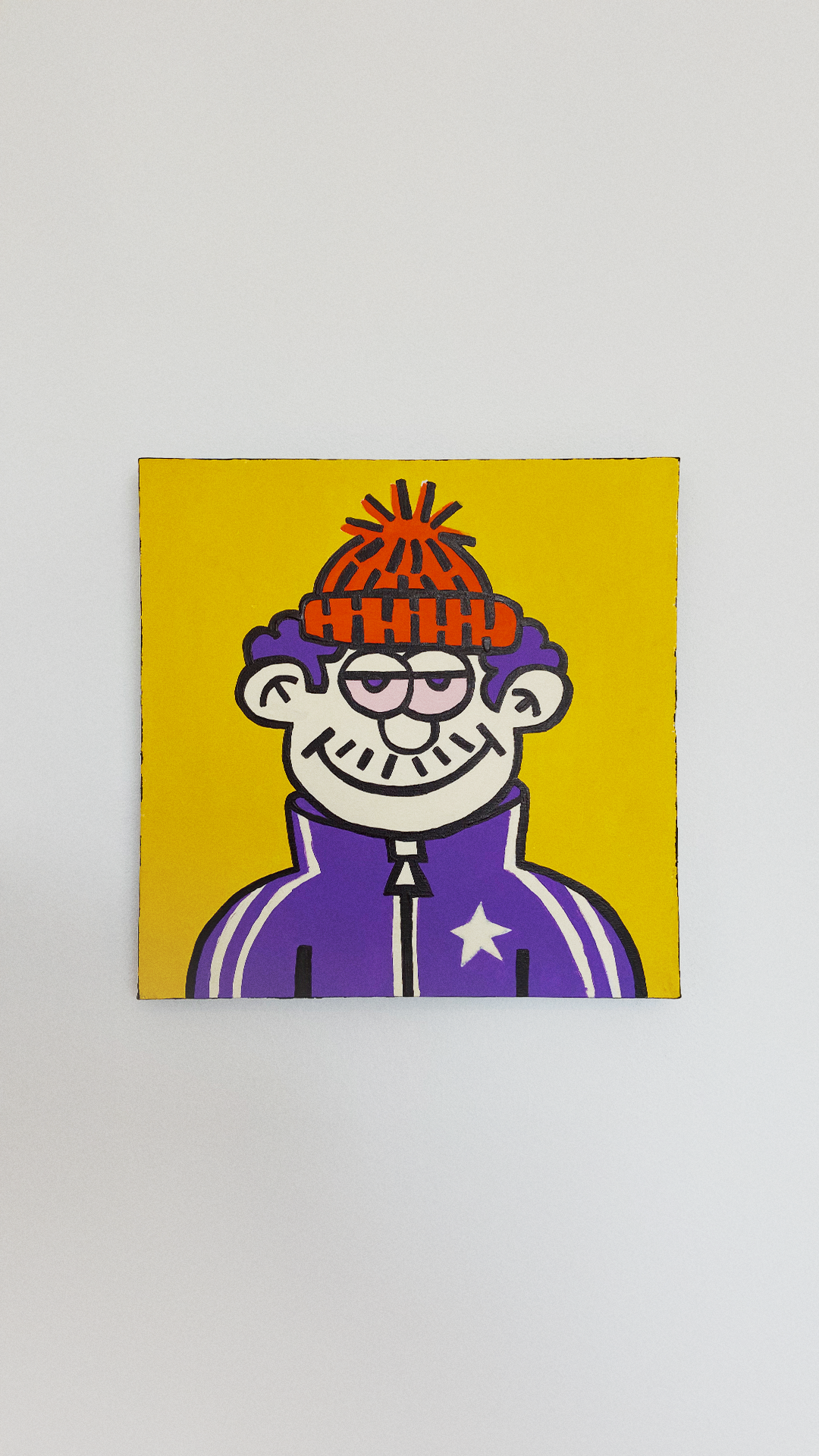 A smiling character in an orange pom-pom hat and a purple jacket with a white star on a yellow background.