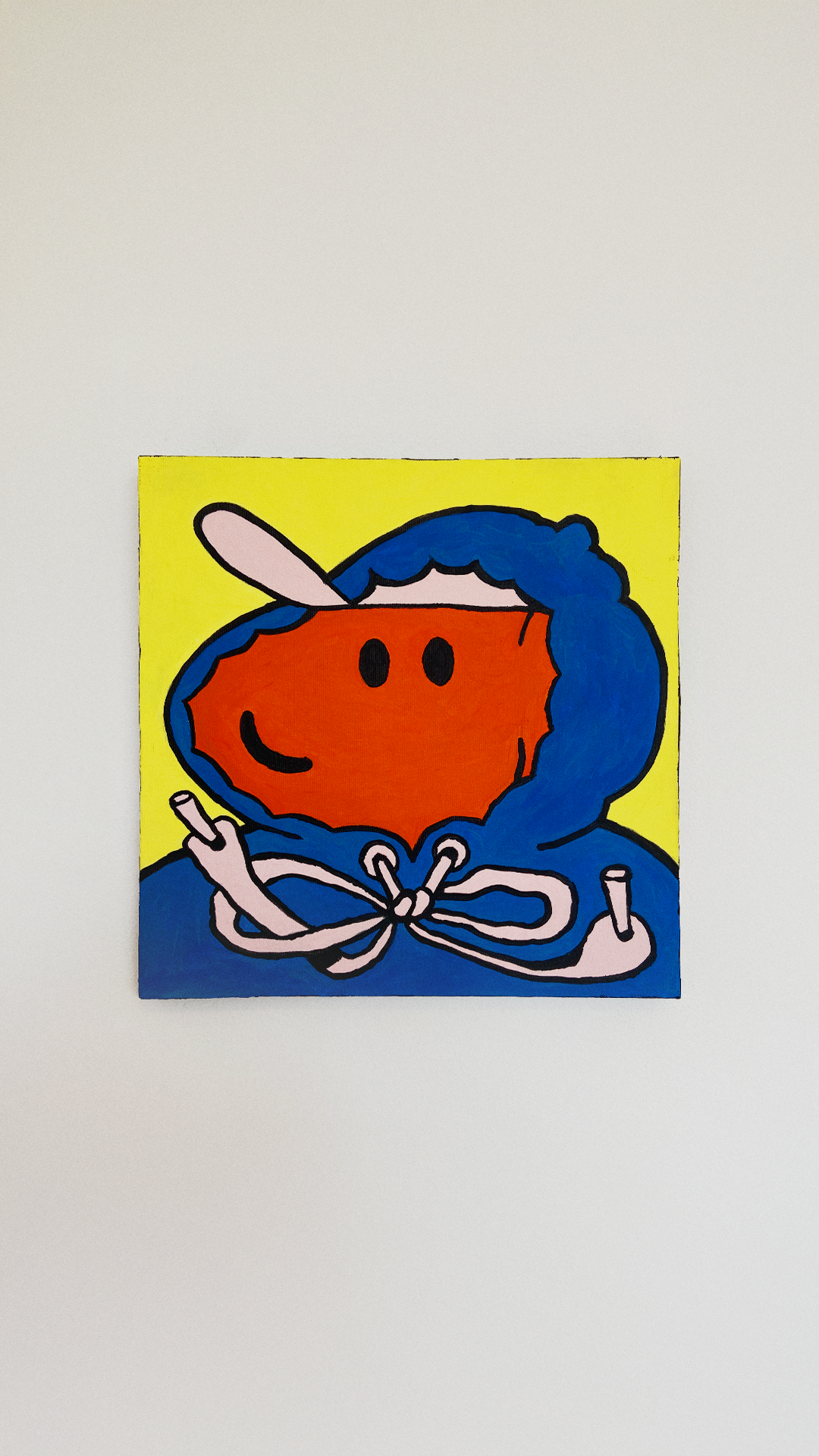 A smiling orange character in a blue hooded jacket and pale pink cap on yellow canvas.