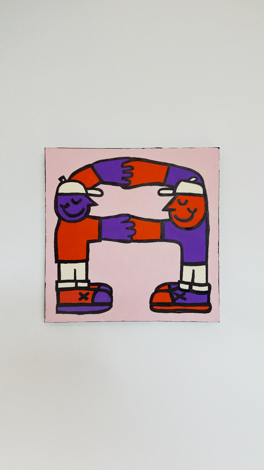 Two smiling orange and purple figures joining their hands to form an arch-like frame on a pale pink canvas.