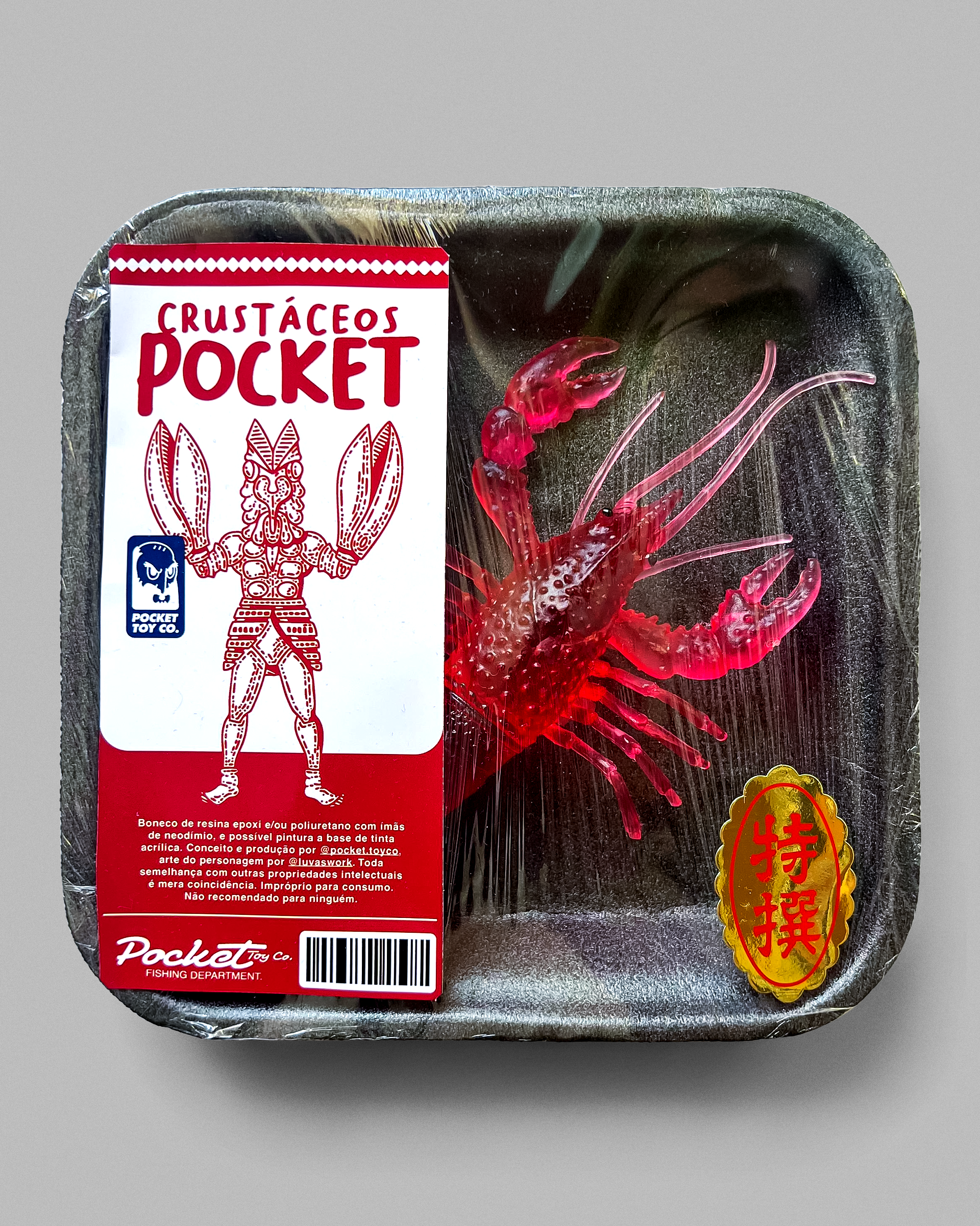 Red Alien Baltan toy in a wrapped seafood tray beside its illustrated Pocket label.