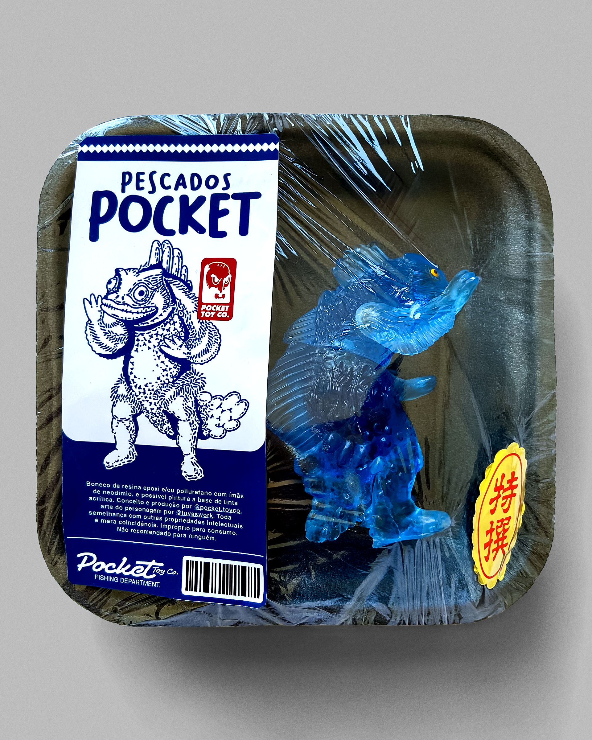 Blue Guesura toy in a wrapped fish-market-style tray with the illustrated Pocket label.